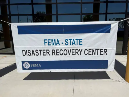 FEMA Disaster Recovery Center sign hanging from building.