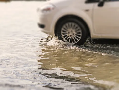 Car driving in flash flood waters.