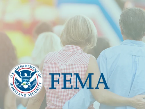 faded image of a couple walking on fair grounds with the FEMA logo