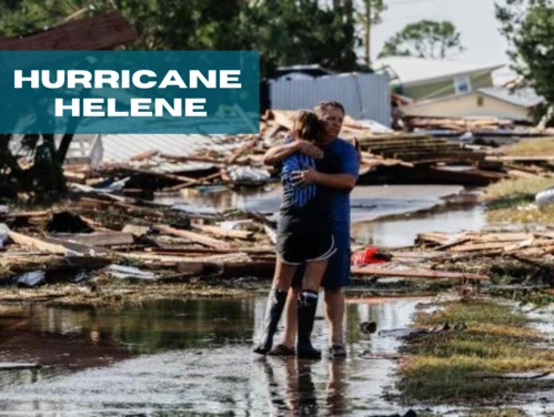 Couple hugging amidst Hurricane Helene damage.