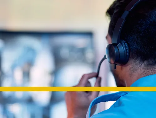man with a phone headset on in front of a computer screen