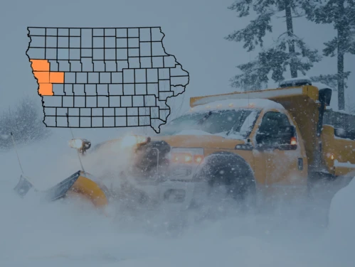 Snow plow clearing deep snow. State of Iowa county map with Crawford, Harrison, Monona, and Woodbury Counties highlighted.