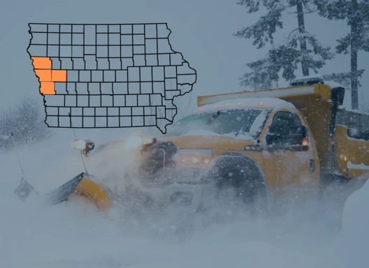 Snow plow clearing deep snow. State of Iowa county map with Crawford, Harrison, Monona, and Woodbury Counties highlighted.