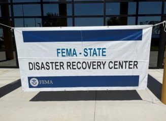 FEMA Disaster Recovery Center sign hanging from building.