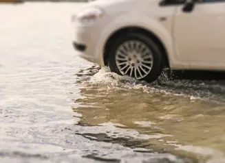 Car driving in flash flood waters.