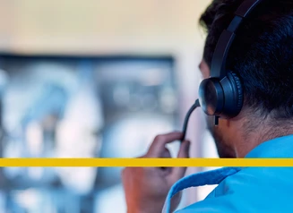 man with a phone headset on in front of a computer screen