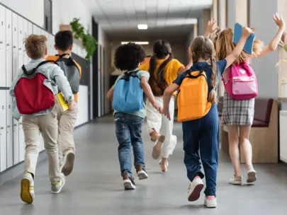 Kids running down school hallway.